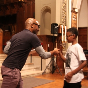 A tutor hands out a certificate to his tutee.