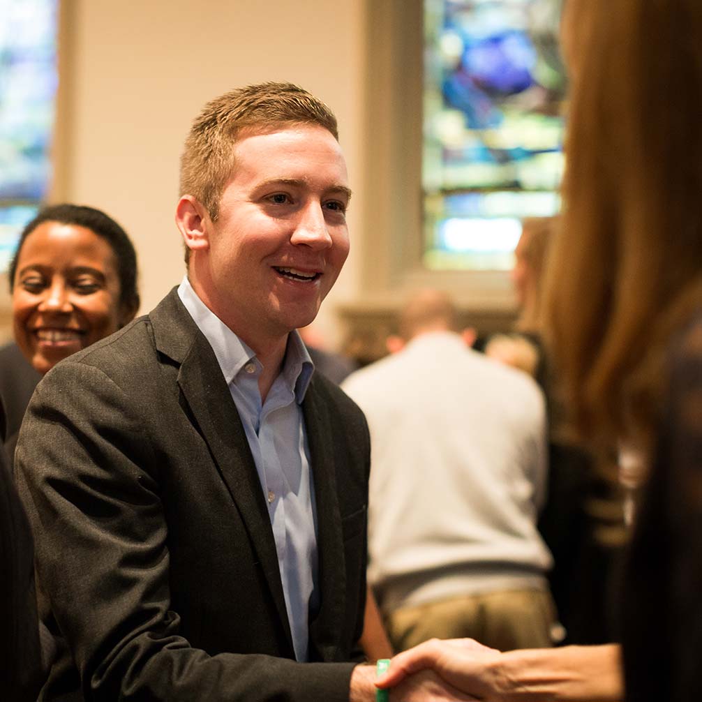 a young man is greeted by a woman in the church sanctuary