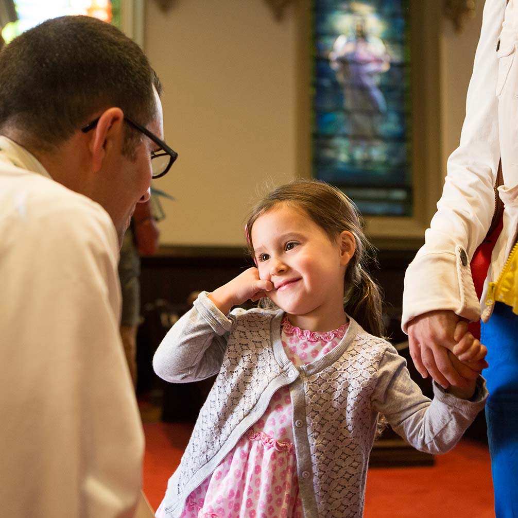 Pastor Andrew Foster Connors greets a little girl in church