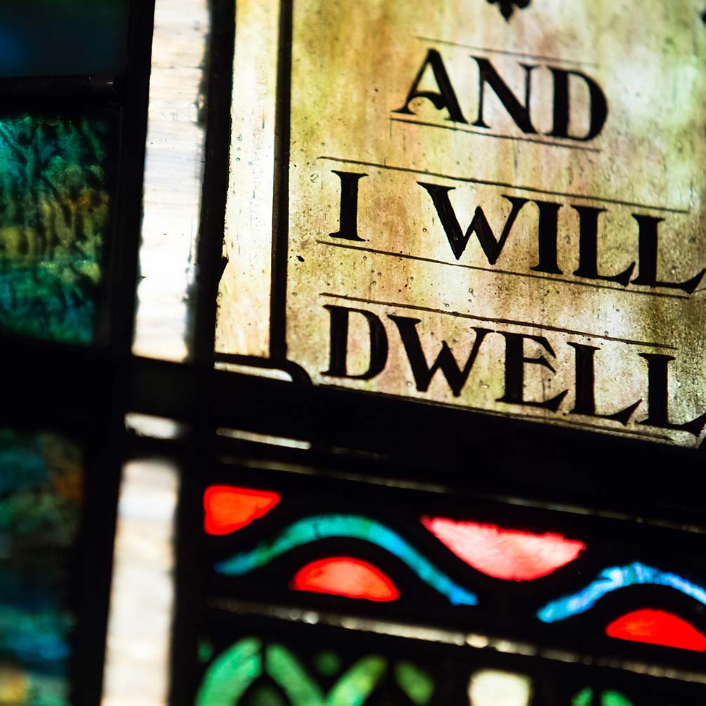 Staine glass with the words "And I will dwell."