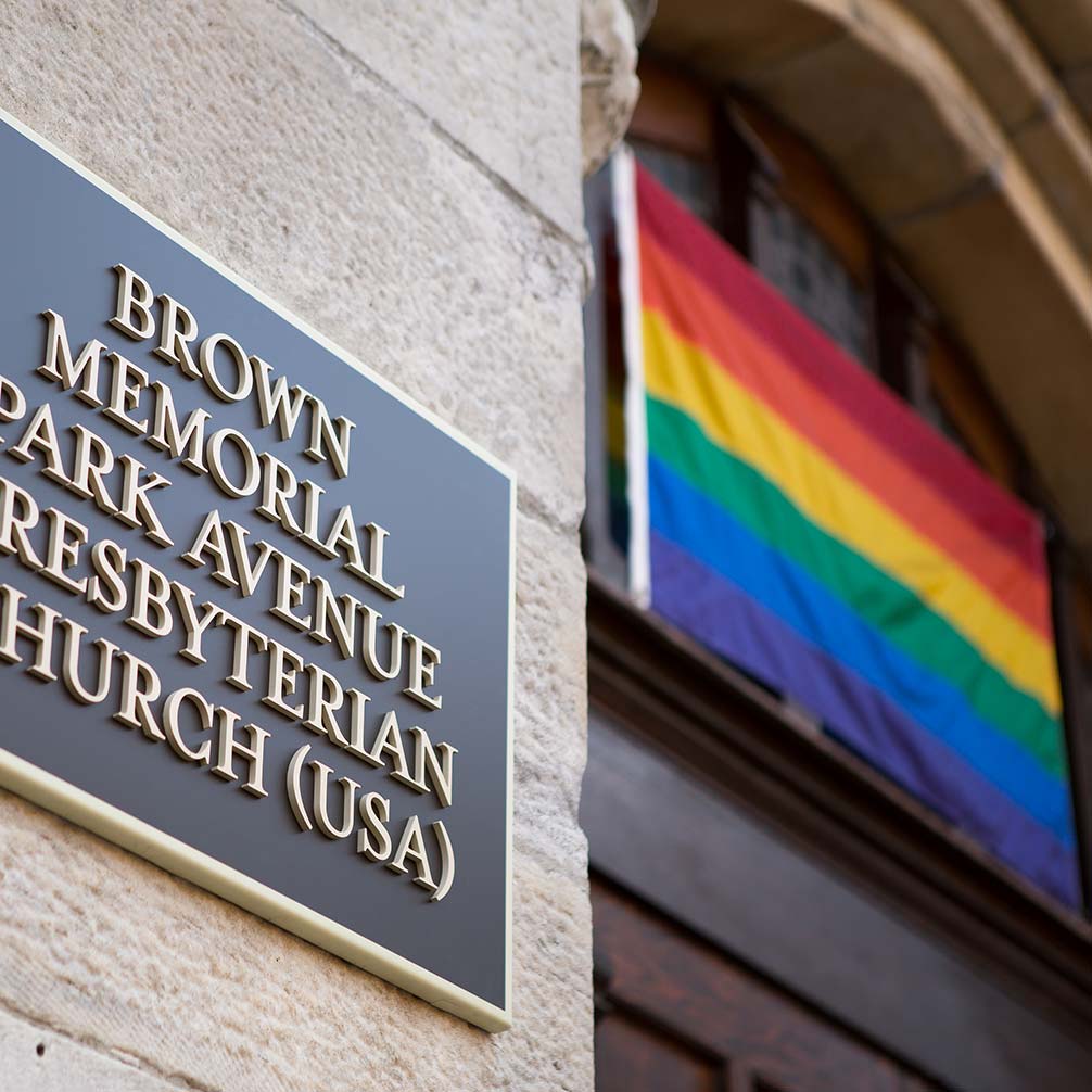 a rainbow flag flies over the door of Brown Memorial Church