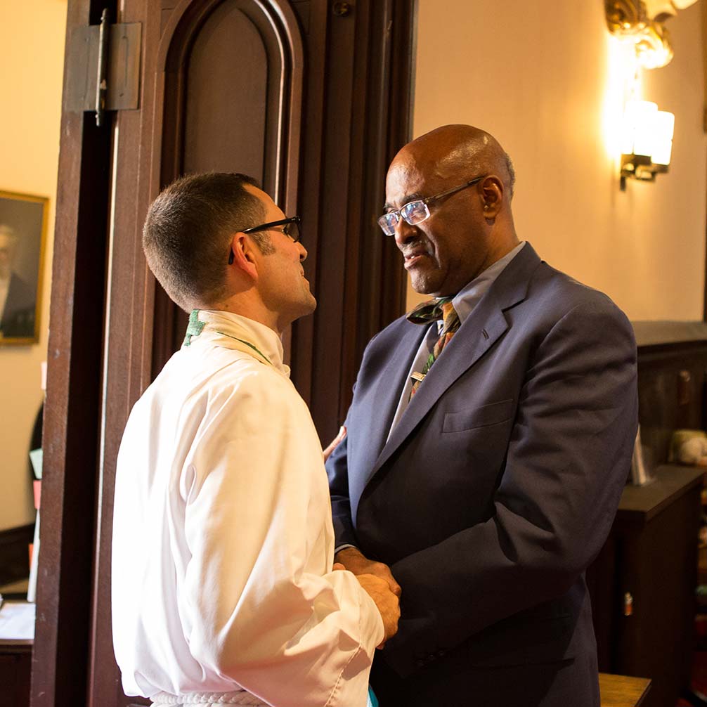 An African American man greets Pastor Andrew Foster Connors