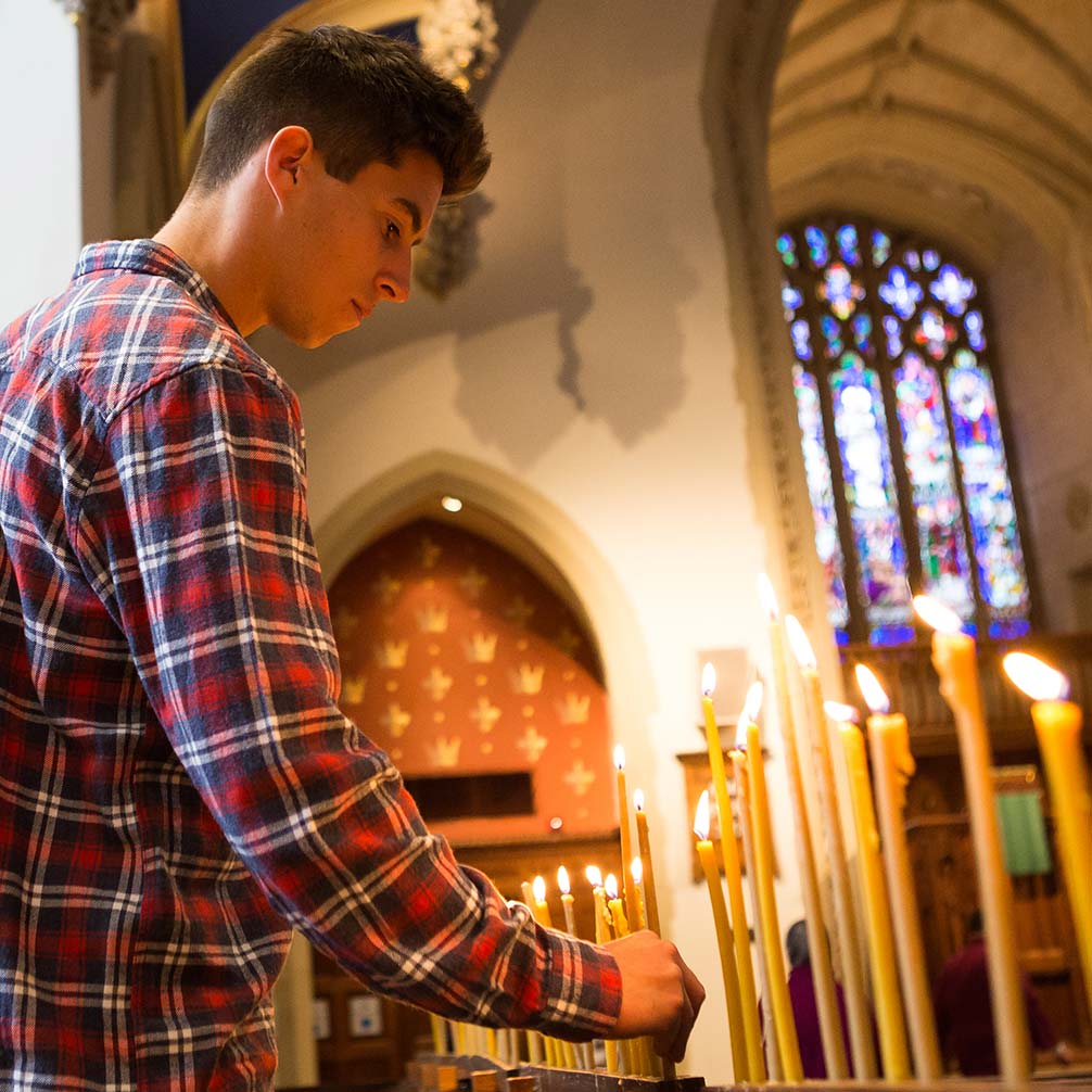 A young man lights candles