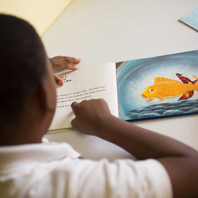 Boy in tutoring program reading picture book