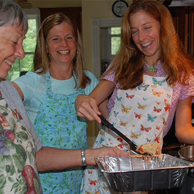 Members of Brown wearing aprons bake a casserole together for Our Daily Bread.
