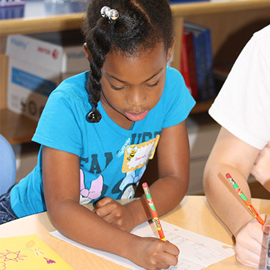 A girl writes during an exercise at the 2016 Soaring Eagles Learning Camp.