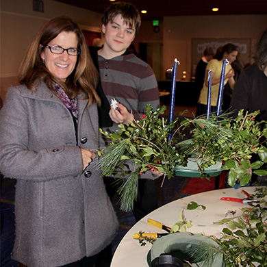 A Brown member and her son hold up an advent wreath they made after worship.