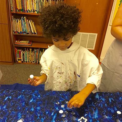 A Sunday School participant decorates the advent art display.