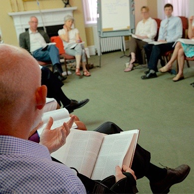 Members of the Adult Bible Study class sit in a circle and discuss scripture.