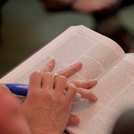 A close-up photo of a bible on someone's lap.