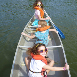 Three girls canoe during the church's annual weekend retreat.