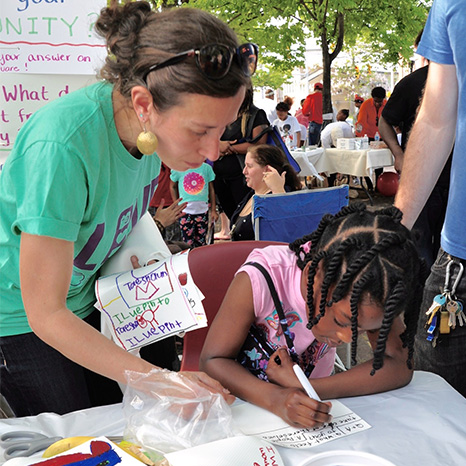 Brown members staff a kids craft table during the No Boundaries Coalition's block party.
