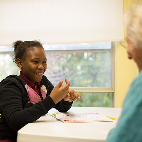 A student in the Tutoring Program works one-on-one with a tutor in a classroom.
