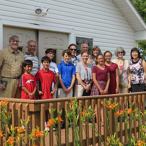 Members of the Global Mission Committee stand outside a chapel in Minnesota during the Pejuhatizizi Family Learning Camp.