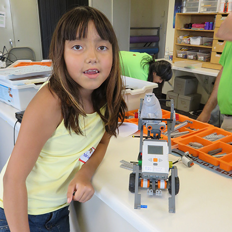 A girl participating in the Pejuhatizizi Family Learning Camp displays a robot she built.