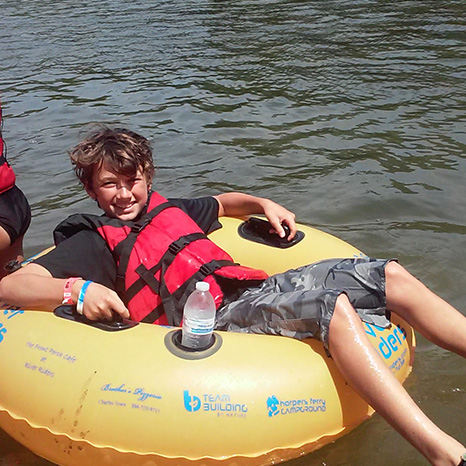 A youth inner tubes during a summer outing with Brown Memorial.