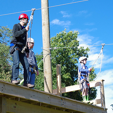 Senior Pastor Andrew Foster Connors and a Brown Memorial youth get ready to zipline at a past All Church retreat.