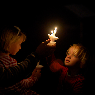 A child looks at his lit candle with awe during the Christmas Eve service.