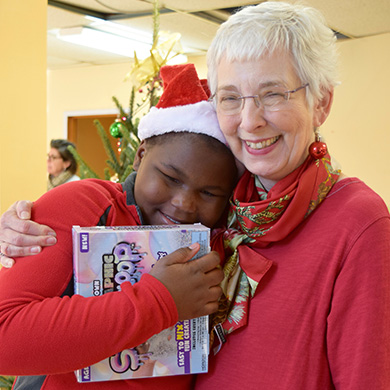 A tutoring student hugs his tutor after receiving a box of Make Your Own SlimeGloop.