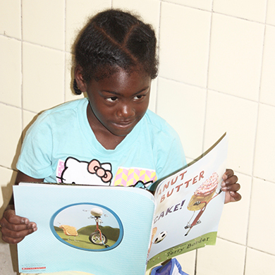 A child reads a book during the Soaring Eagles Learning Camp.