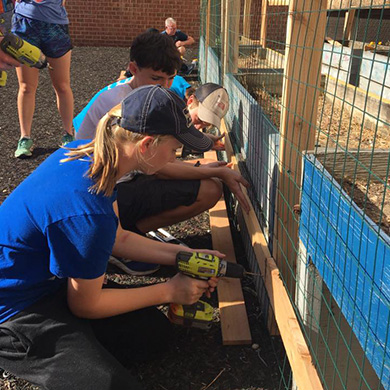 The Brown Green Team helps build a vegetable garden with students at Eutaw-Marshburn Elementary School.