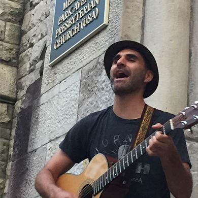 Brown member Rob Tracy plays his guitar on the church front steps.
