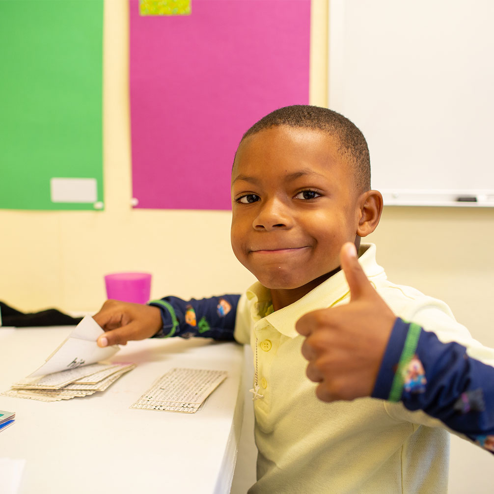A boy gives a thumbs up during a session at the Brown Tutoring Program.
