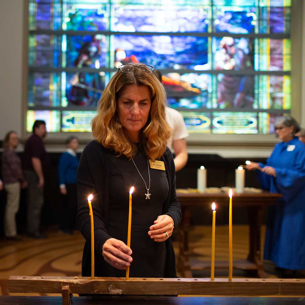 A congregant lights a candle during worship.