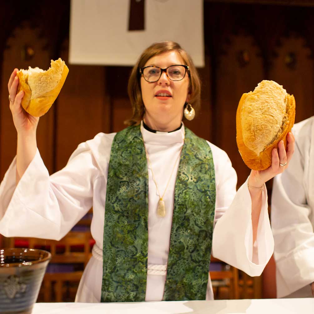 Associate Pastor Michele Ward breaks bread during communion.
