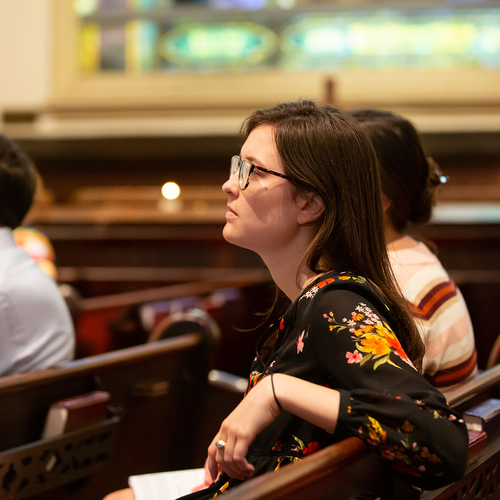 A woman listens to the Sunday sermon during worship.